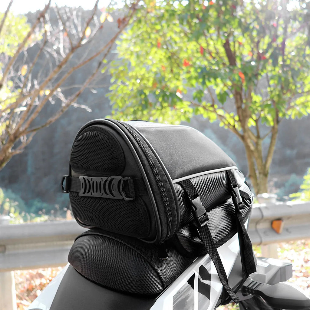 Black motorcycle seat bag with reflective strip, showing convertible crossbody strap and internal pocket organisation