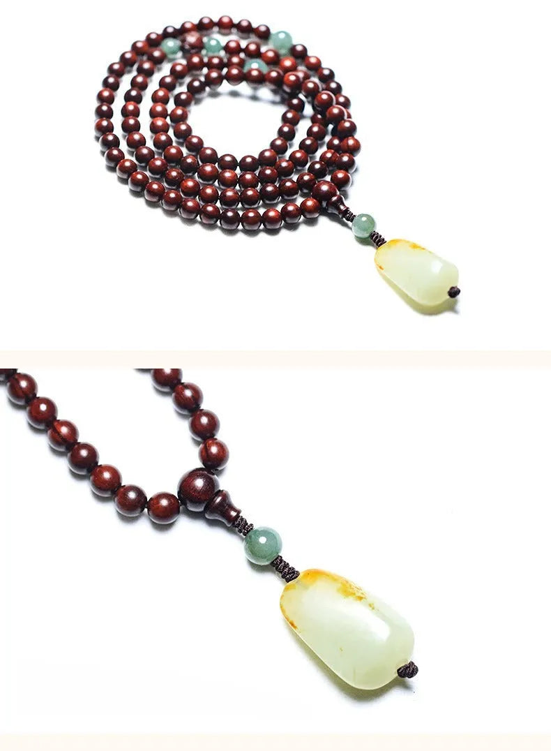 Close-up of a rosewood bead bracelet with 108 beads and a carved Hotian jade pendant.
