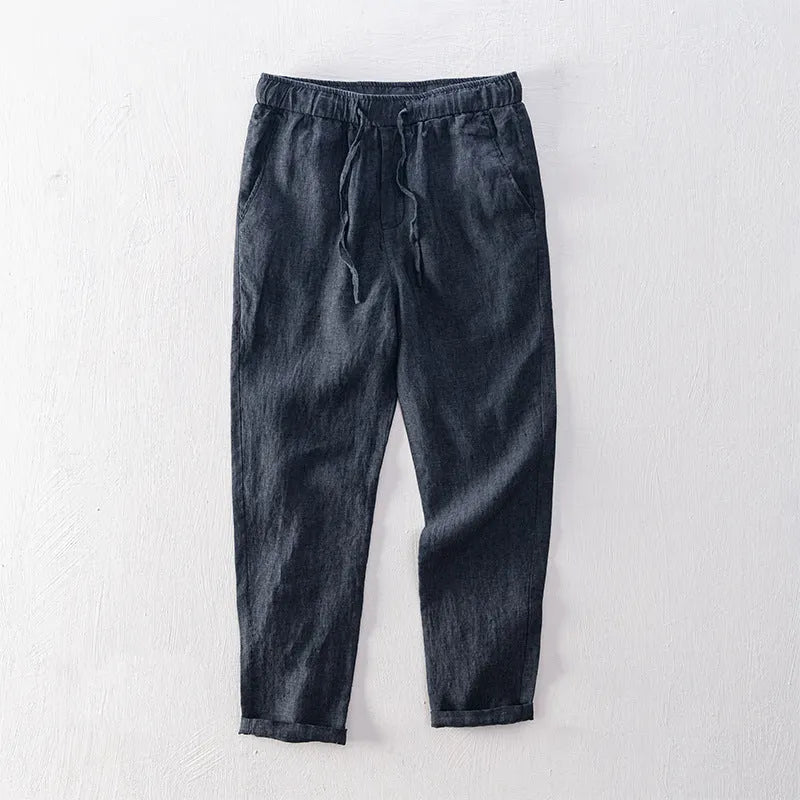 Men's straight-leg linen trousers in dark grey laid flat, showing mid waist and relaxed fit