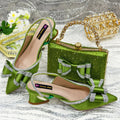 Women's black pointed toe sandals with elastic band and matching square rhinestone clutch bag on a neutral background.