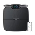 Black eight-electrode intelligent body fat scale on a hardwood floor.