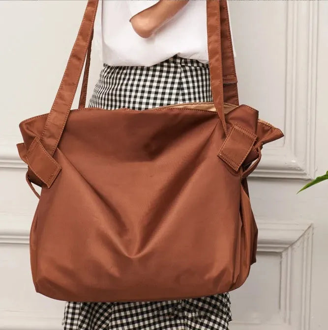 Women's black expandable shoulder crossbody bag made from Oxford cloth for travel and daily use.