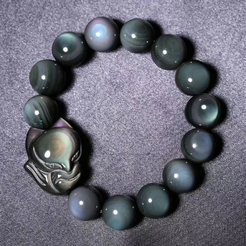 Black obsidian stone bracelet with carved fox design in cartoon style, showing texture and adjustable sizing