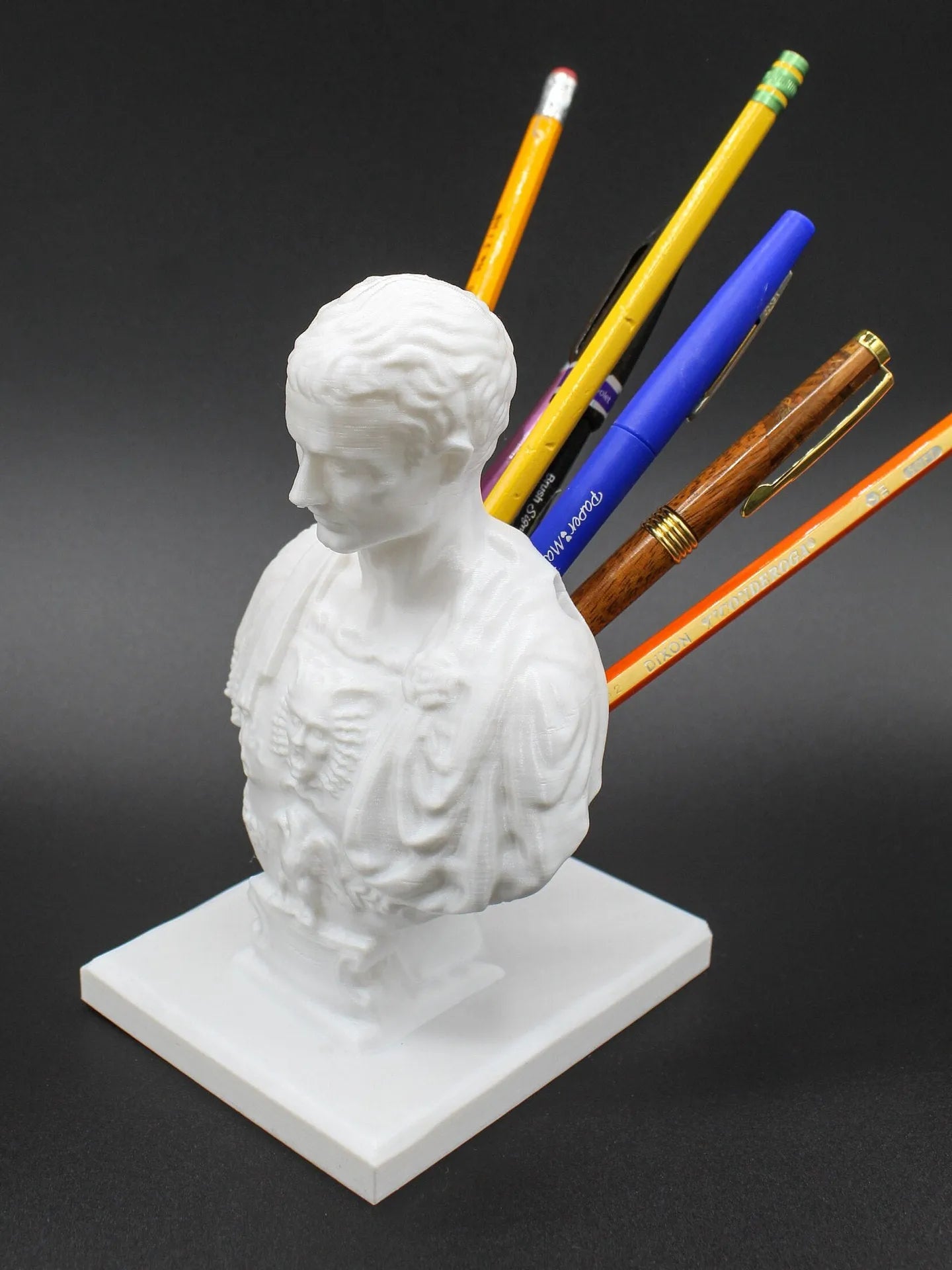 White synthetic resin American creative character model used as a desk pen holder.