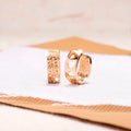 Rose gold women's earrings with a hollowed out heart shape and circular frame.