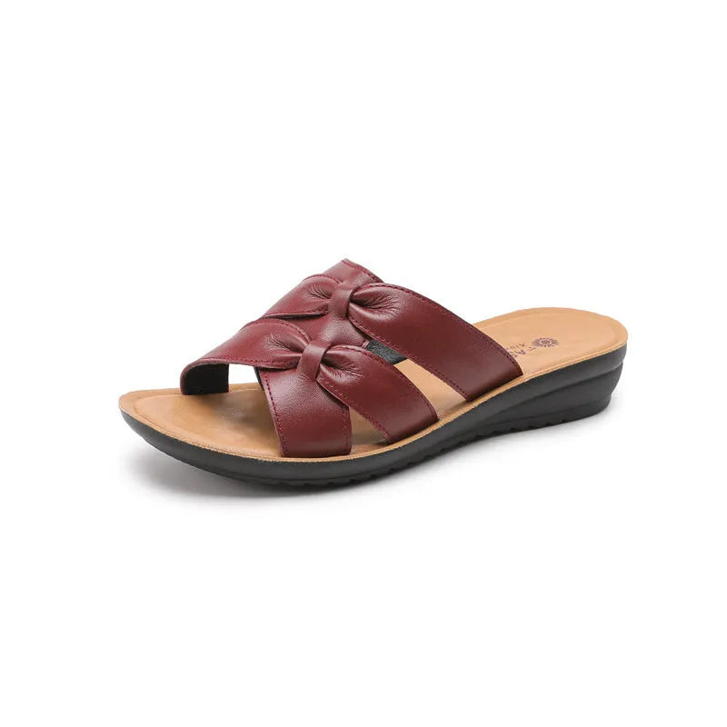 Women's beige cowhide slippers with a soft sole, shown from the side.