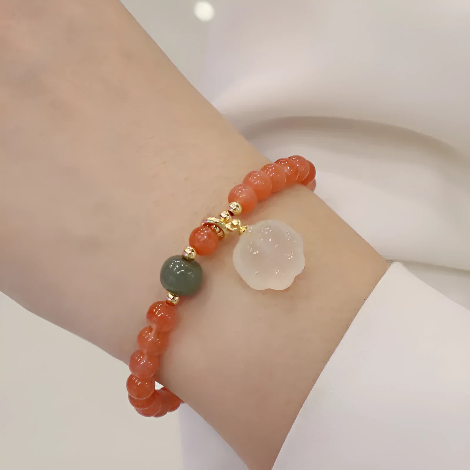 Polished red agate and green jade women's bracelet with a cat's paw charm.