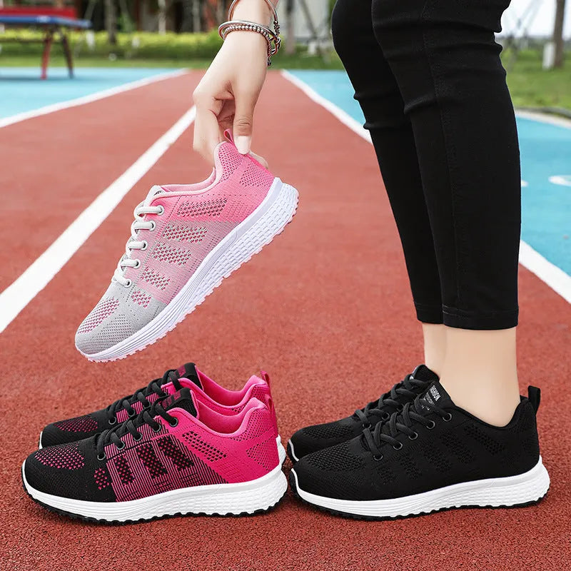 Women's black flyknit casual running shoes with white soft sole and flat heel on a grey background.