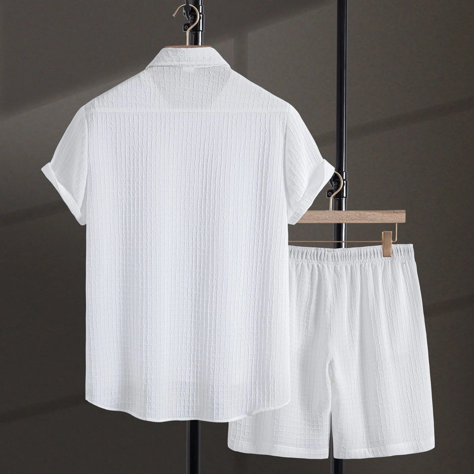Men's black jacquard short sleeve shirt and shorts suit laid flat showing cotton blend fabric texture