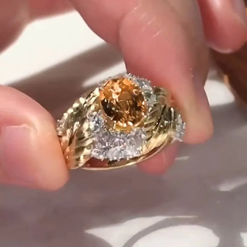 Gold women's ring with embossed feather design and yellow zircon stones on geometric shape