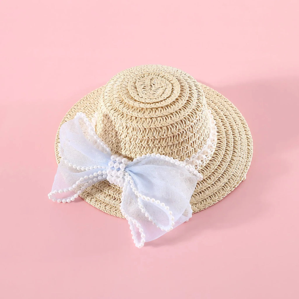 Pink pearl bow straw hat for a cat on a mannequin head, showing Lafite leaf weave and butterfly detail.