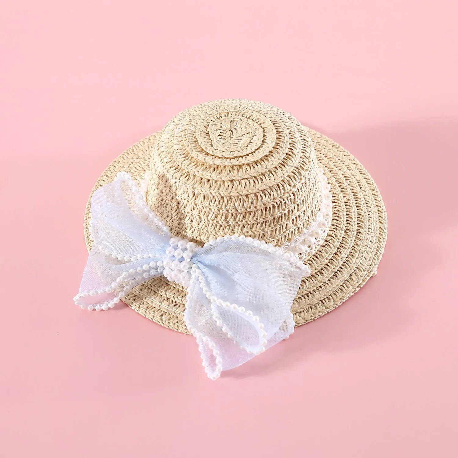 Pink pearl bow straw hat for a cat on a mannequin head, showing Lafite leaf weave and butterfly detail.