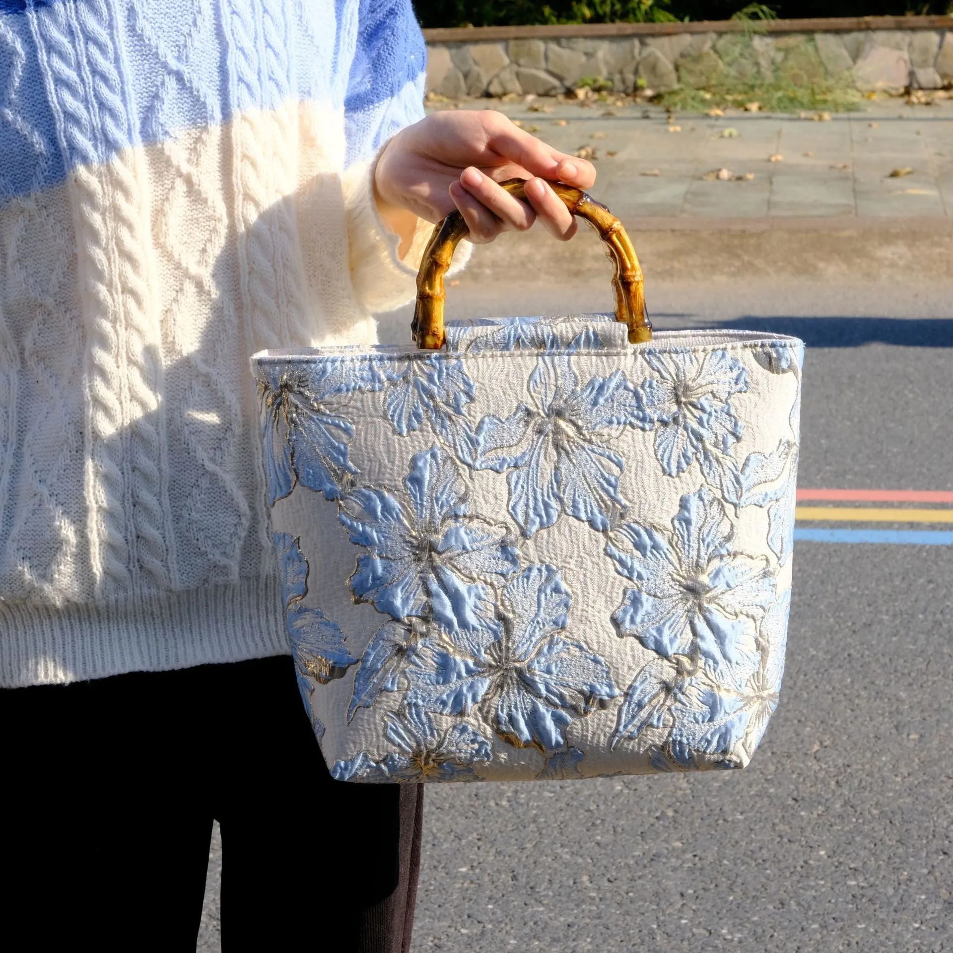 Light blue canvas bag with gold floral pattern showing double shoulder straps and square 30cm shape