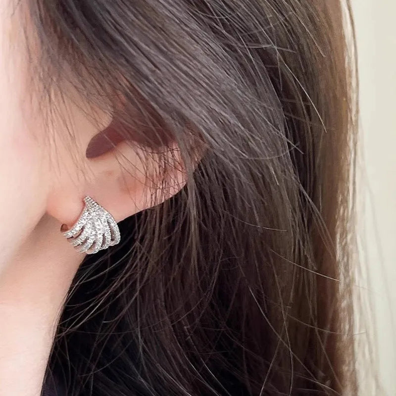 A pair of geometric drop earrings with a platinum electroplated finish on zircon.