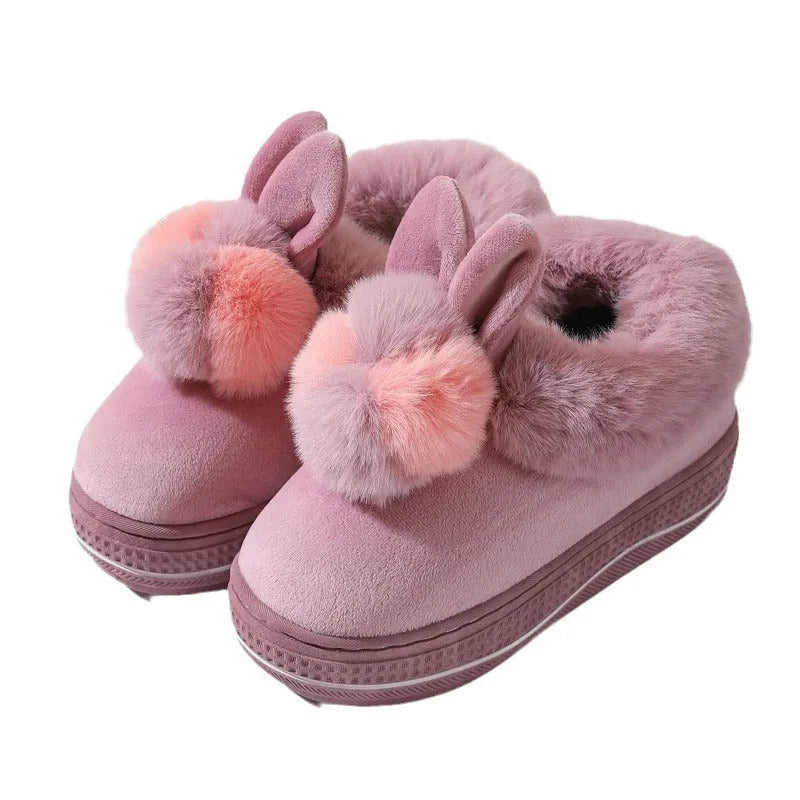 A pair of thick-soled grey plush oversleeve slippers with a textured non-slip sole.