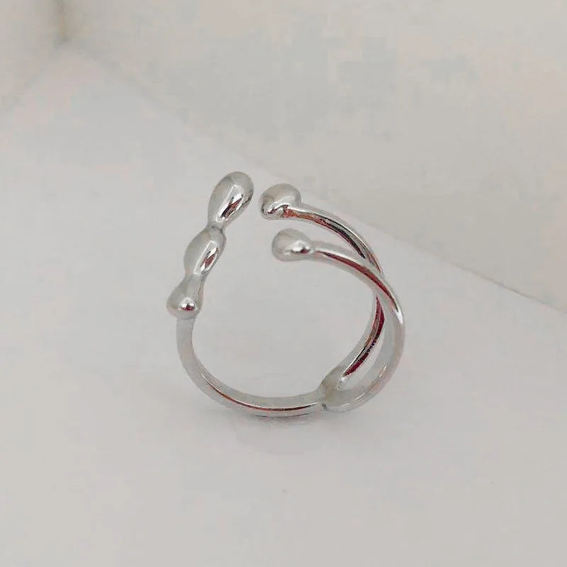Gold and silver brass women's fashion ring with spherical design detail.
