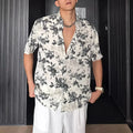 Men's loose-fit black short sleeve shirt with a white floral print pattern.
