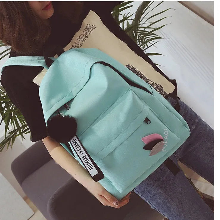 College style canvas rucksack in green with leaf pattern, showing anti-theft features and shoulder straps