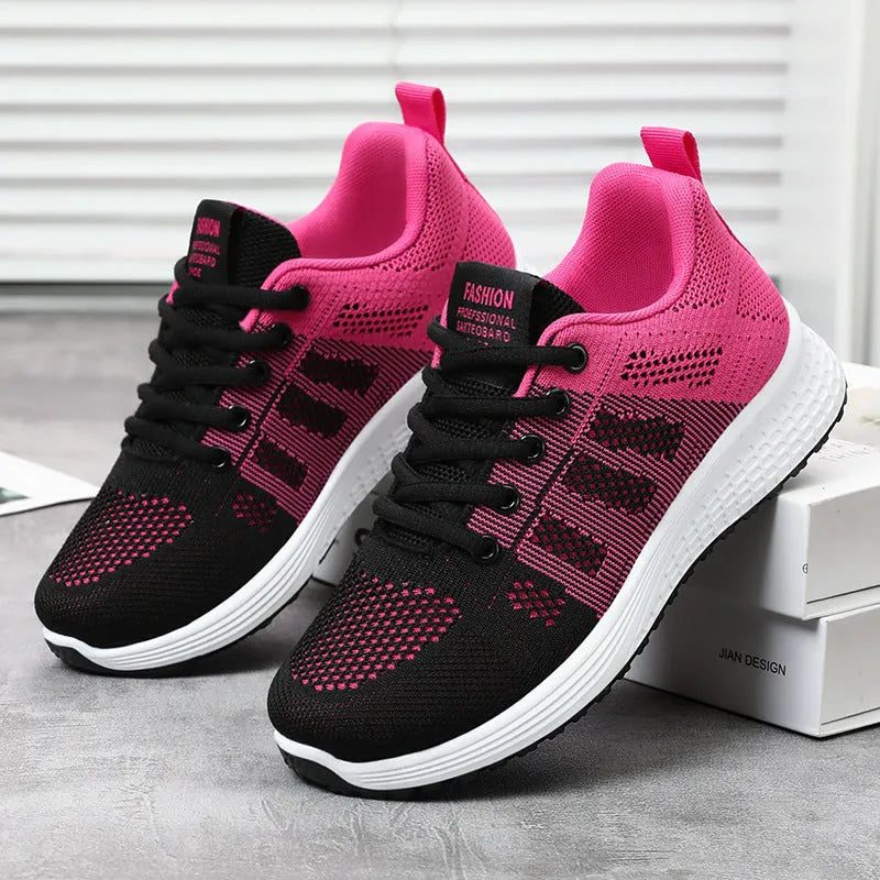Women's black flyknit casual running shoes with white soft sole and flat heel on a grey background.