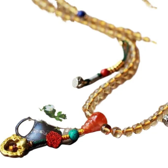 Yellow natural Brazilian citrine bracelet with 1mm beads and filament details on a wrist.