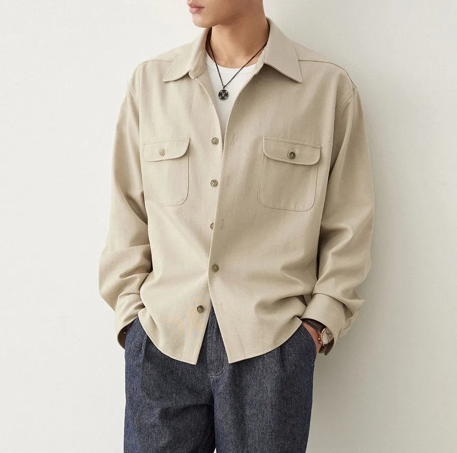 Men's light sand rice coloured casual shirt with simple lapel and long sleeves on a hanger.
