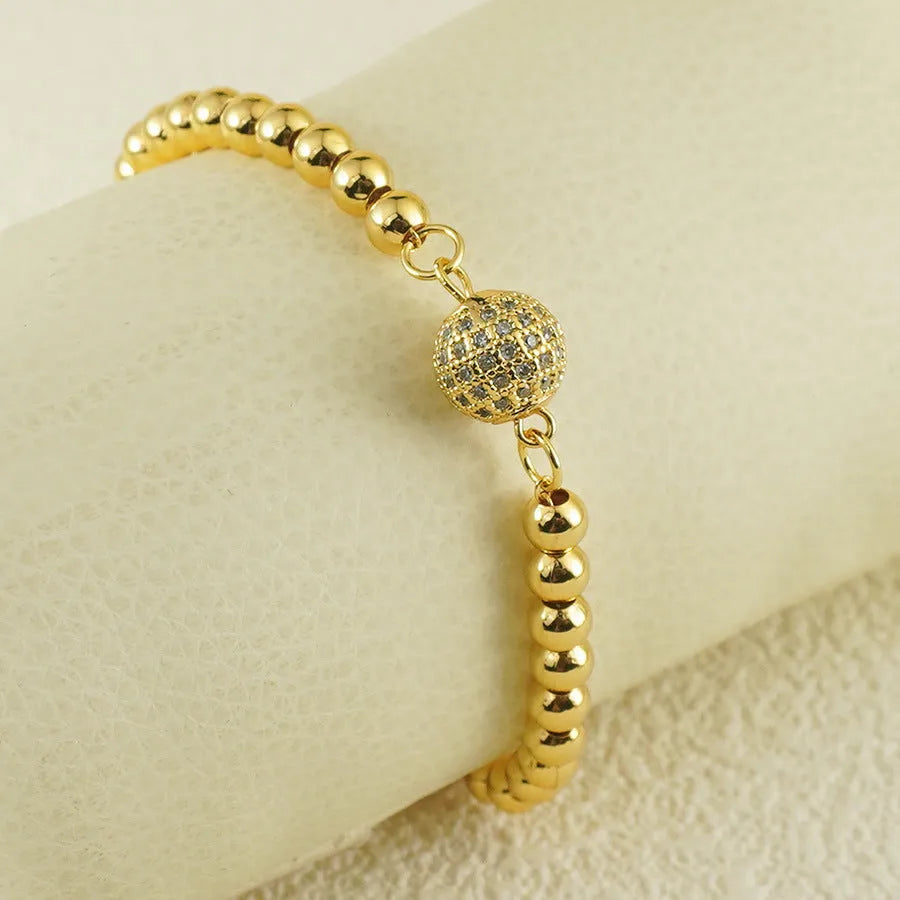 Close-up of a women's copper bracelet with a heart-shaped charm holding a round zircon stone, Arabic style design.