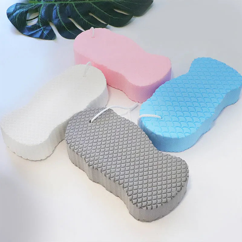 White 3D fish scale pattern bath sponge ball on a bathroom surface.