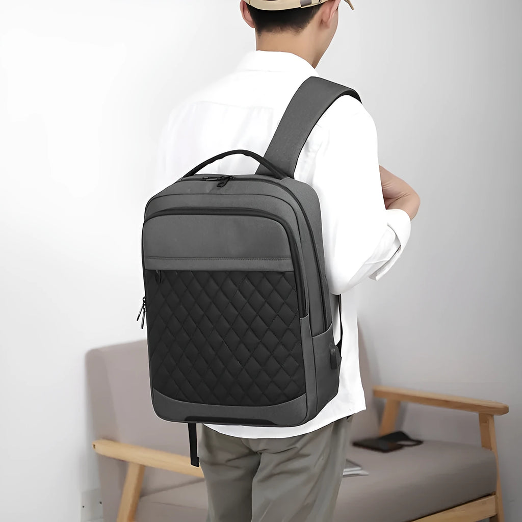 Men's Oxford cloth travel backpack in black showing curved shoulder strap and diamond mesh back panel