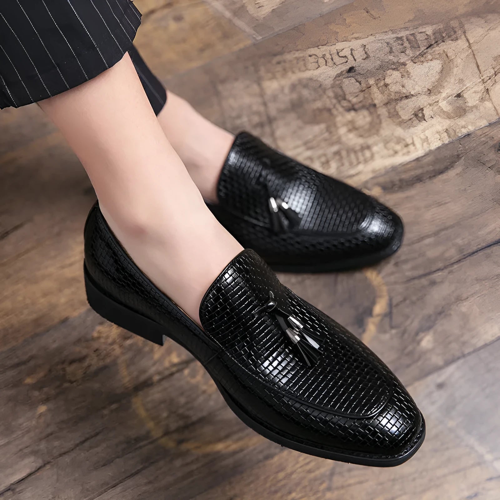 Men's black pointed slip-on shoes with tassel detail on a low-top PU upper