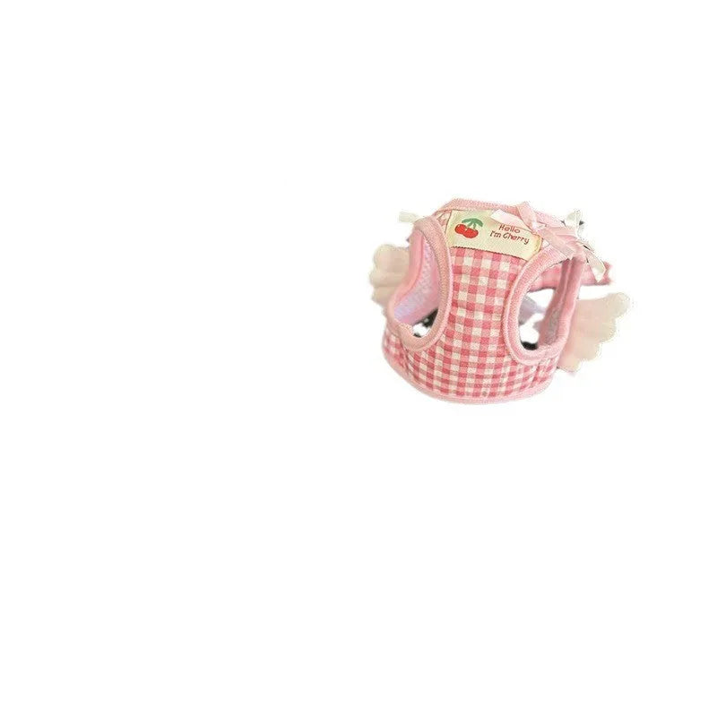 A pink cotton chest and back harness with a hand holding rope for a small dog.