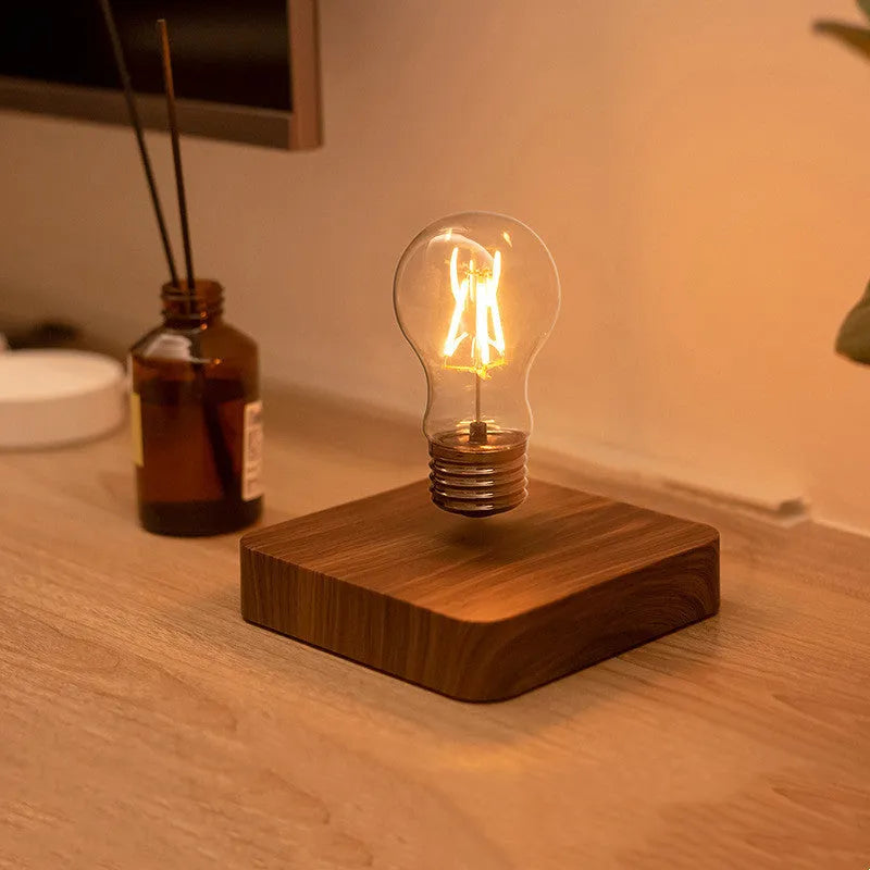 Self-rotating wireless powered maglev bulb with warm yellow light on a compact ABS base