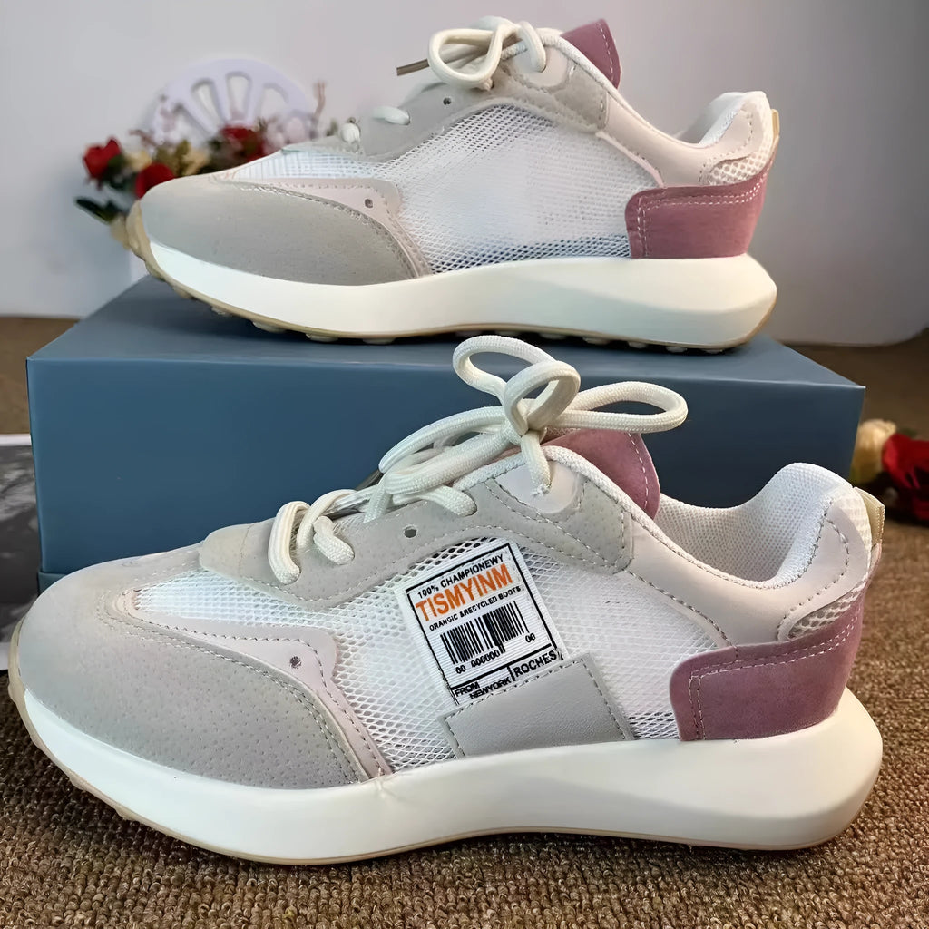 Women's low-top retro sneaker in grey or pink with round toe and rubber sole.