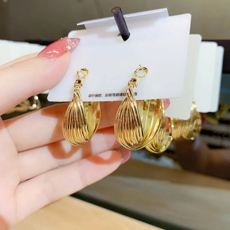 Twisted metal eardrop earring with real gold plating, round geometric shape, gold colour, drop style for women