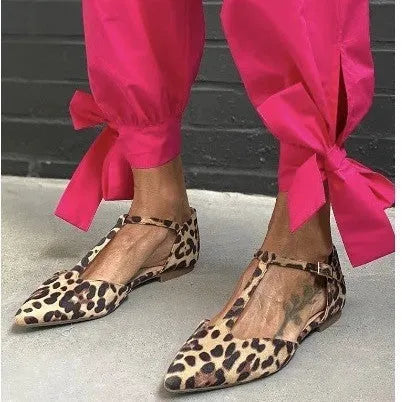 Women's low-top leopard print pumps with a chunky heel and cross shoulder straps on a pointed toe.