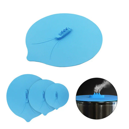 A silicone cooking lid with a ship-inspired design, featuring a three-port steam release system and a convenient hook for easy storage.