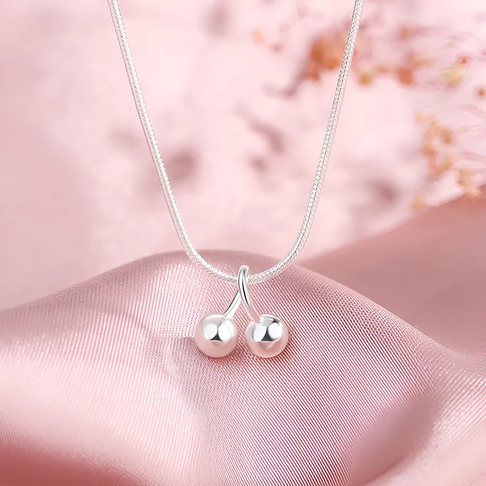 Silver cherry pendant necklace on an adjustable snake bone chain for women.
