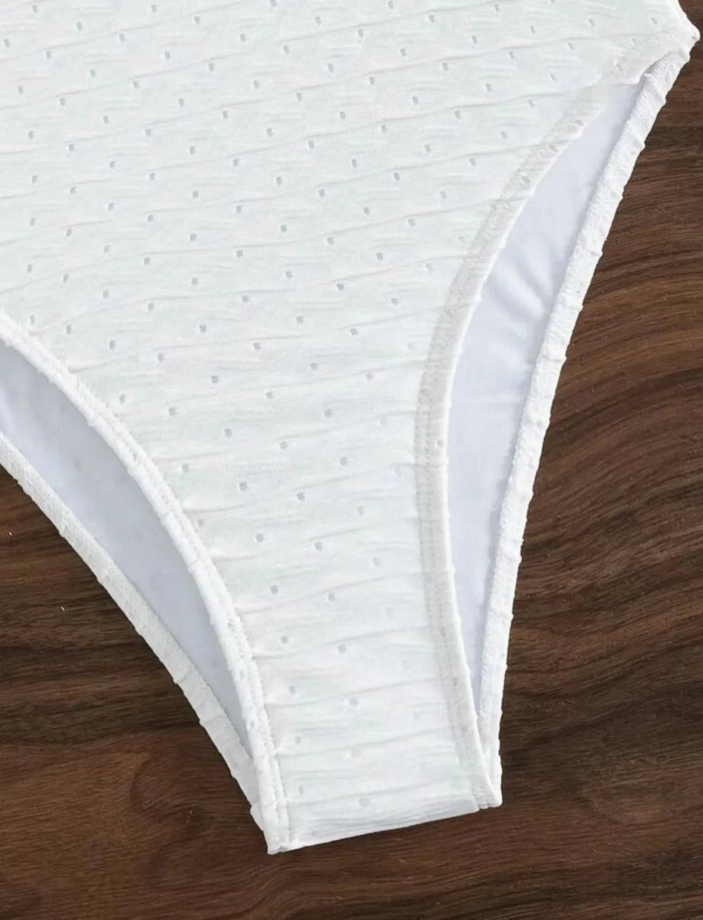White women's one-piece swimsuit with sling design on mannequin
