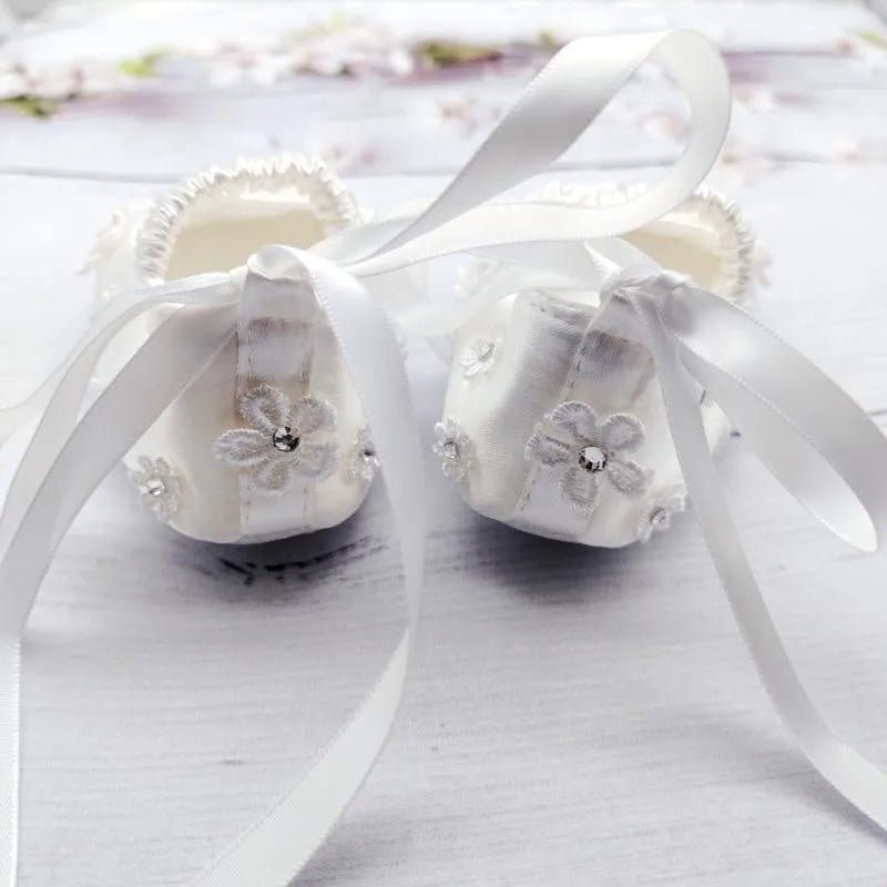 White baby soft bottom cloth princess shoes with rhinestone detail on a white background