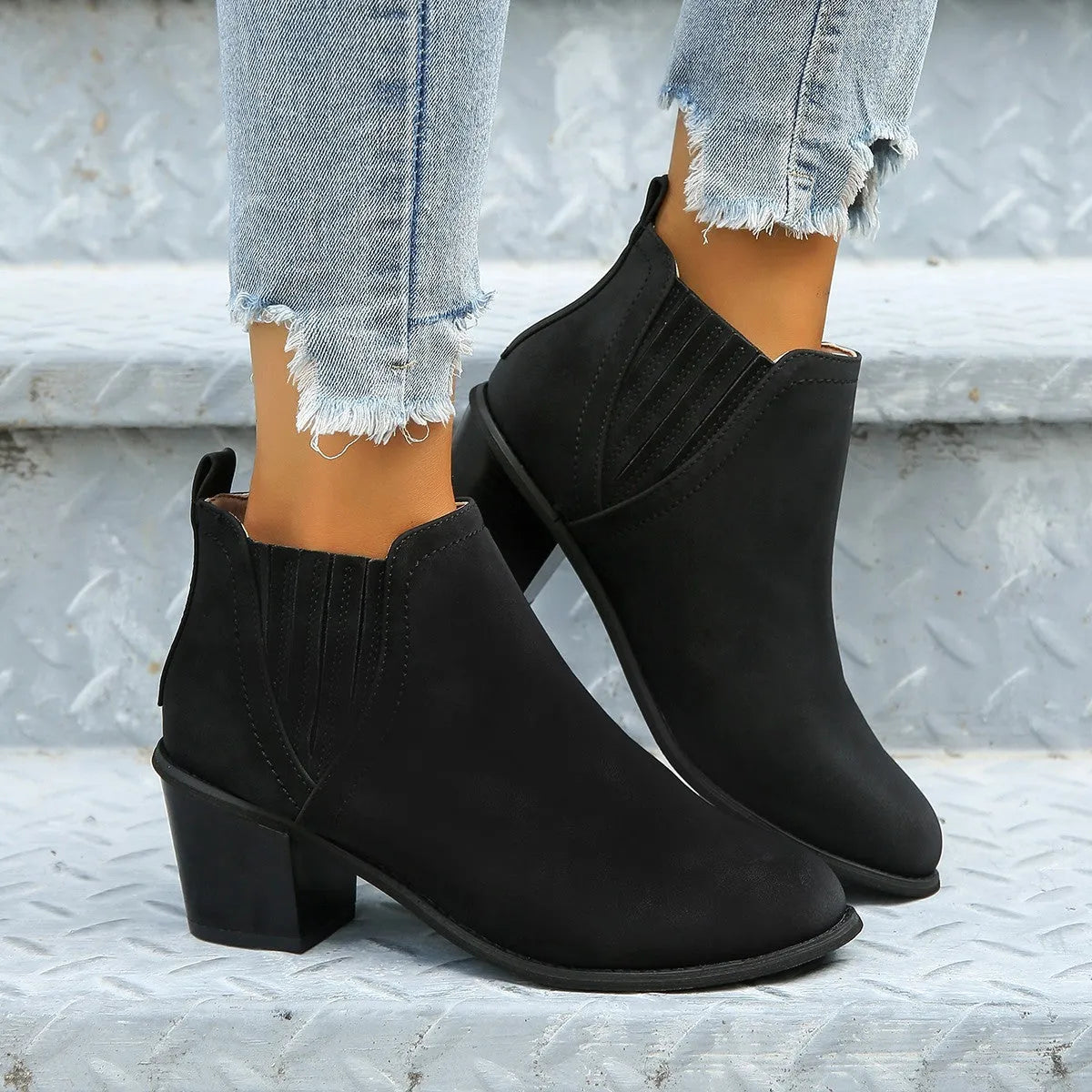 Black women's ankle boots with a pointed toe and thick square heel on a rubber sole.