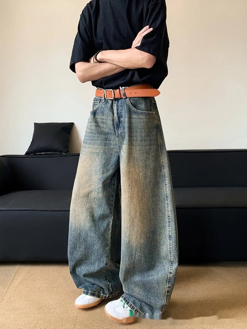 Men's retro blue distressed denim jeans with a slimming wide-leg fit and machete wash detail.