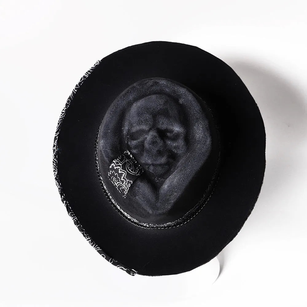 Handmade wool felt hat with conical crown and skull embroidery on a denim base.
