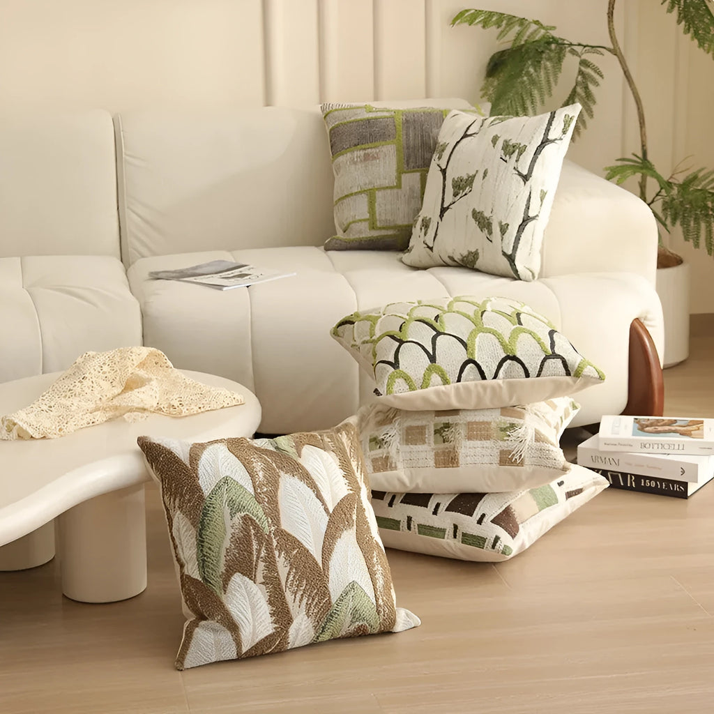 Square jacquard cushion cover with a detailed woven botanical pattern in a retro colour, shown on a grey sofa.