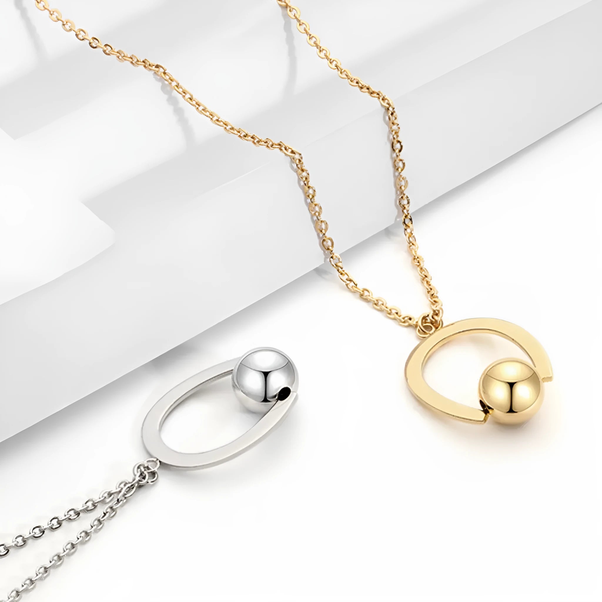 Stainless steel necklace with geometric pendant on a cross chain, shown in gold colour.