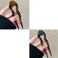A set of simple U-shaped acrylic hair barrettes with a retro ball detail in beige and caramel colours.