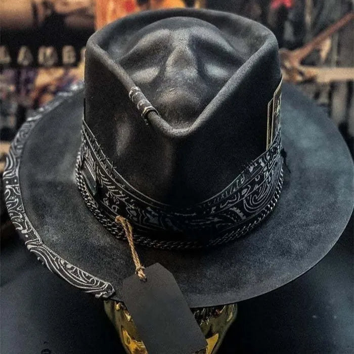 Handmade wool felt hat with conical crown and skull embroidery on a denim base.