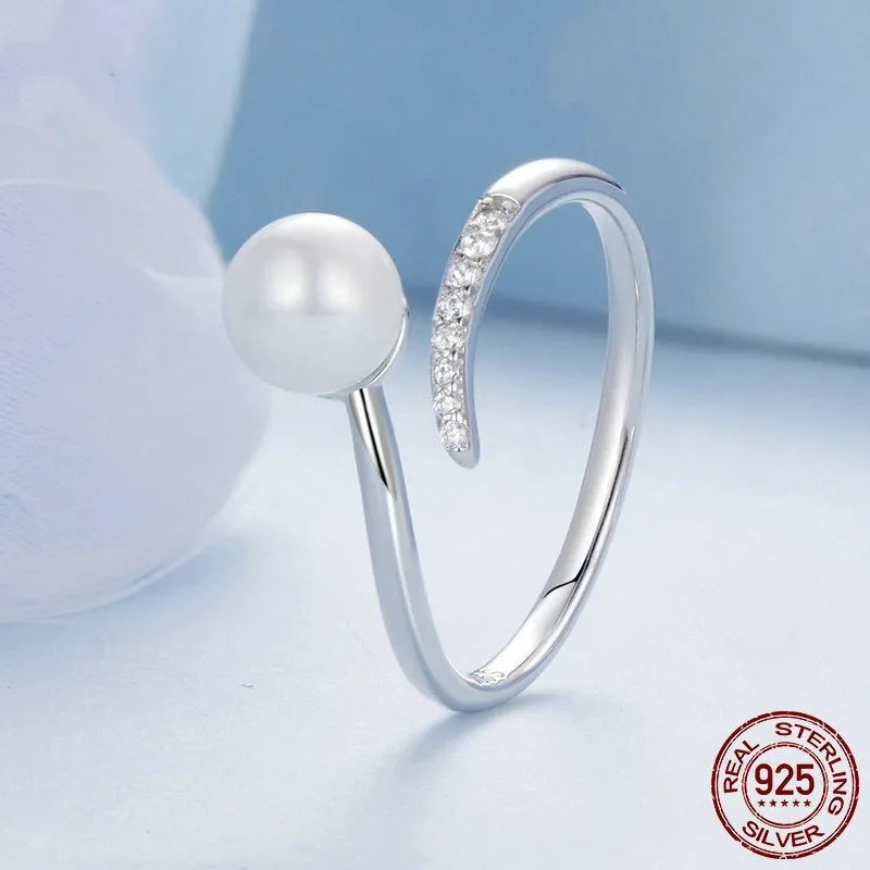 Silver adjustable open loop ring with shell pearls on white background
