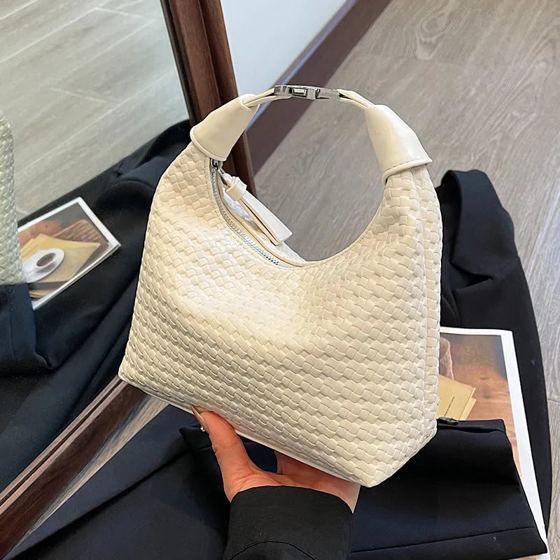 Soft beige PU bucket-shaped messenger bag with an external pocket, shown open to reveal internal document organiser.