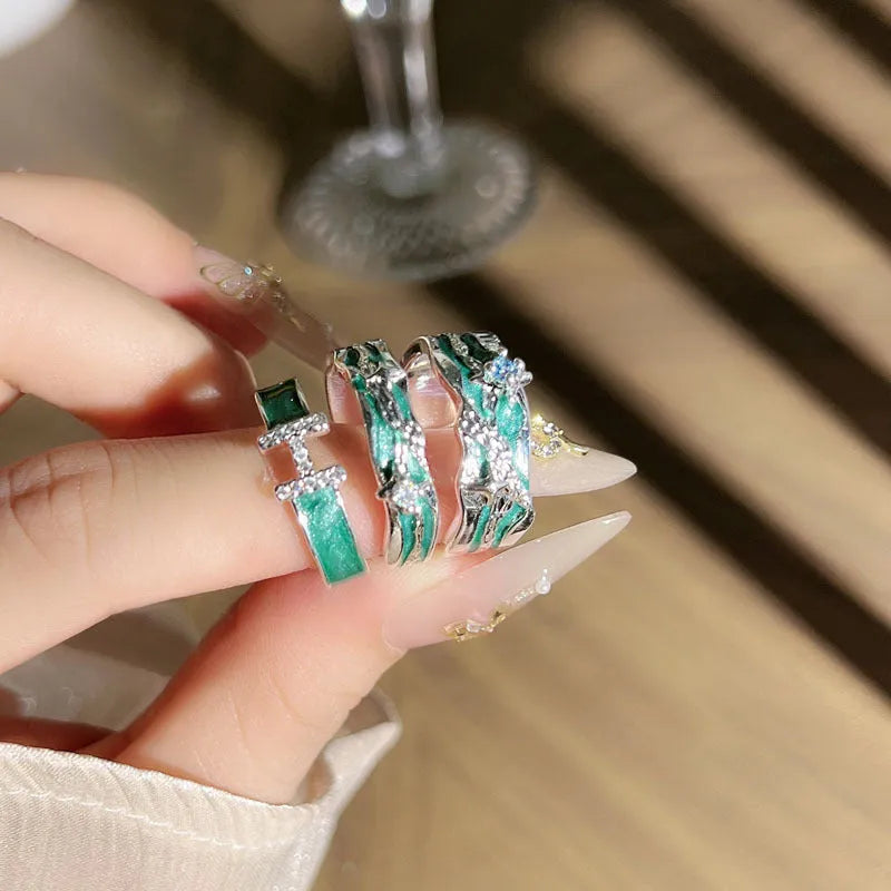 Mint green enamel eight-point asterism ring on a copper base, showing asymmetric and folded design details.