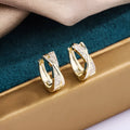 A pair of geometric earrings in 14K yellow colour, made from copper with a zircon treatment.