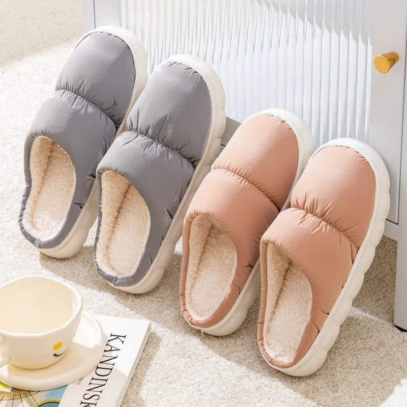 A pair of blue down cotton slippers with a thick sole, artificial leather upper, and plush lining for indoor winter wear.